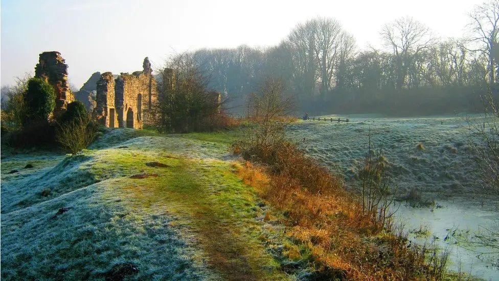 A frosty pathway leading up to the ruins on a midwinter morning