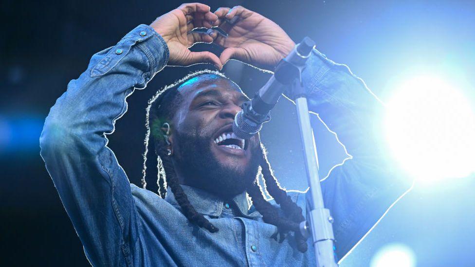 Burna Boy making a heart sign