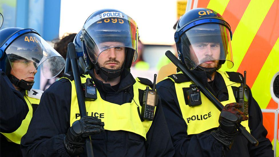 Riot police during a confrontation with anti-migration protesters in Weymouth