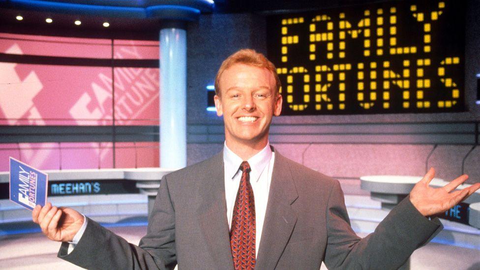 Les Dennis smiling on the Family Fortunes set in 1990