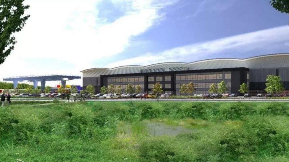 Three-storey warehouse buildings with grass in foreground