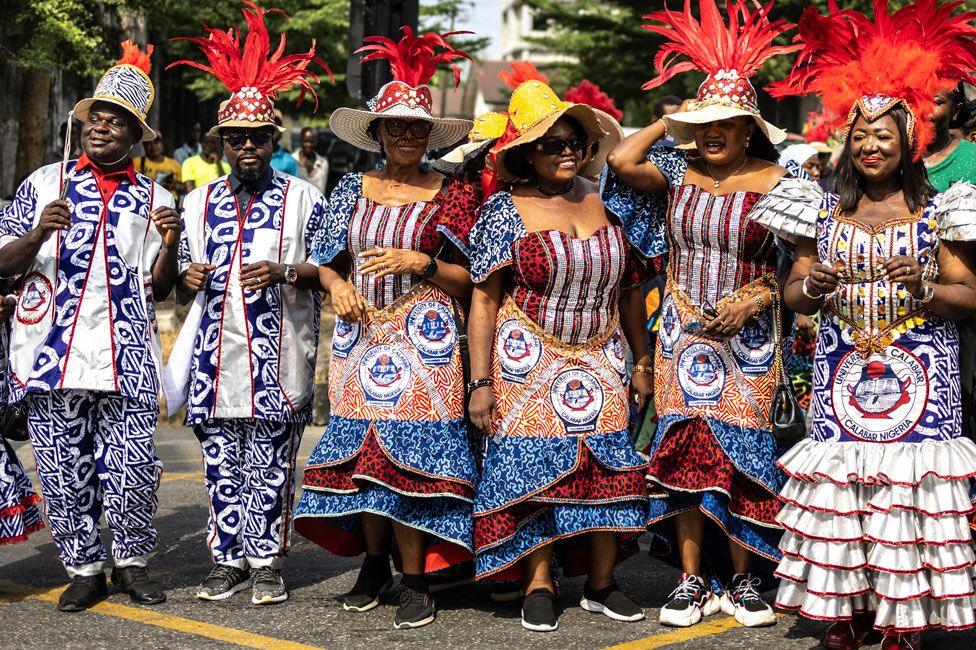 A troupe from the University of Calabar pose in outfits made from material printed with the university's logo