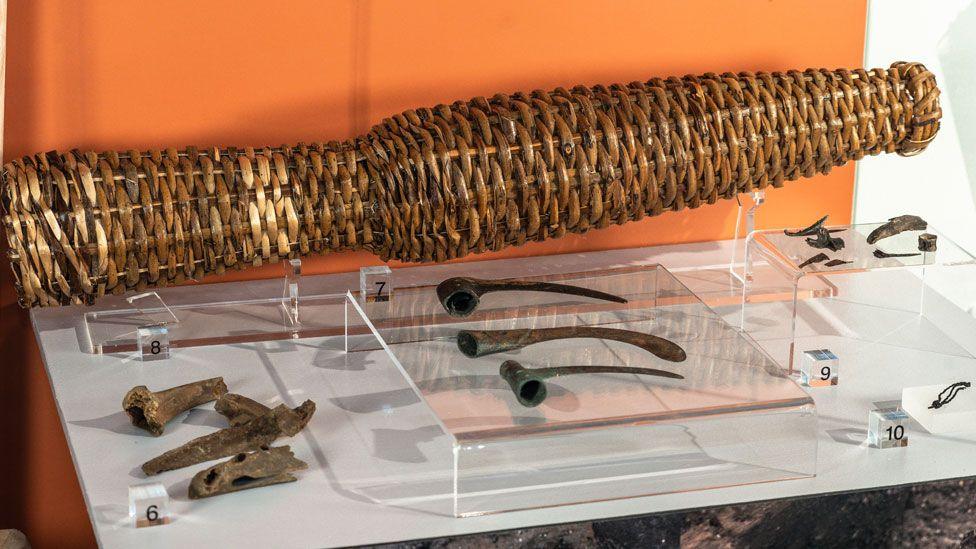 View of a replica eel keep made from reeds, a selection of Bronze Age sickles and fish and animal bones on display at Peterborough Museum