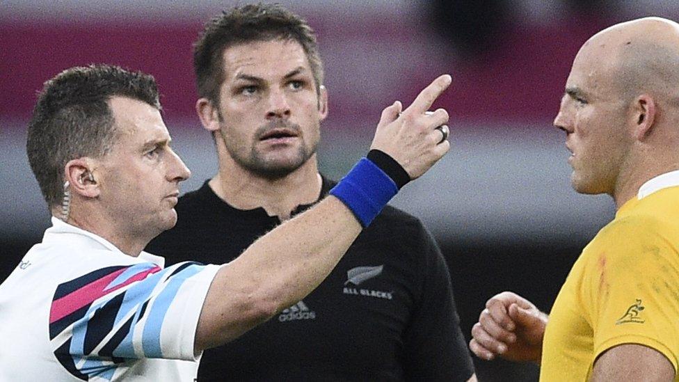 Nigel Owens makes a point to World Cup final captains Richie McCaw and Stephen Moore