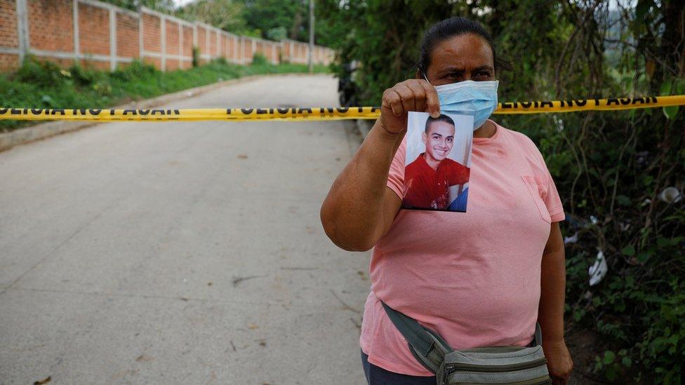 Marleny Barrientos shows a picture of her son who went missing six years ago and is believed to be at the site authorities are excavating