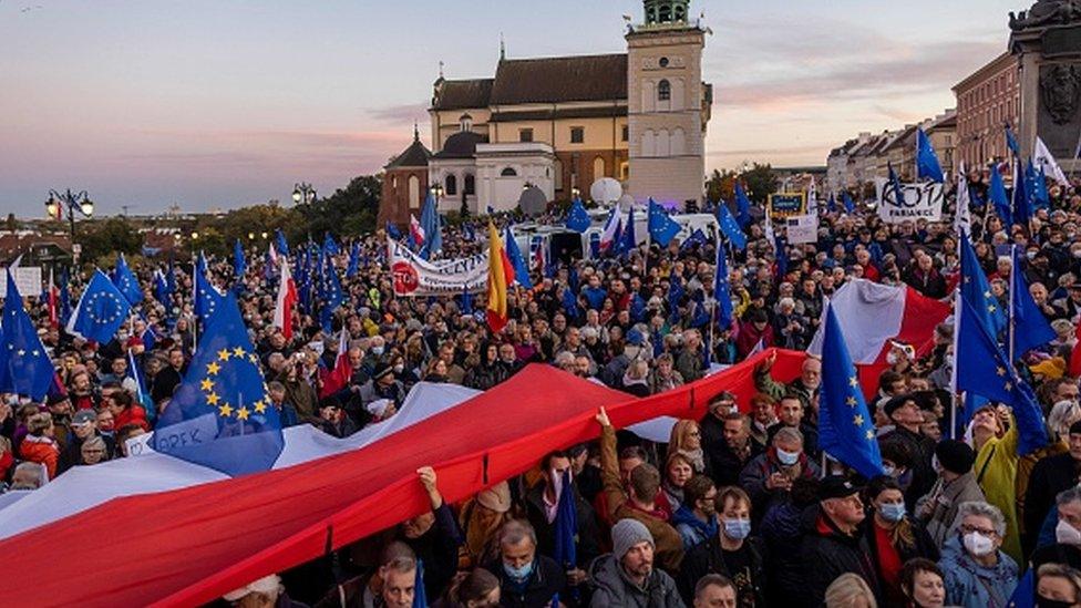 Protesters wave flags at a pro-EU rally in Warsaw