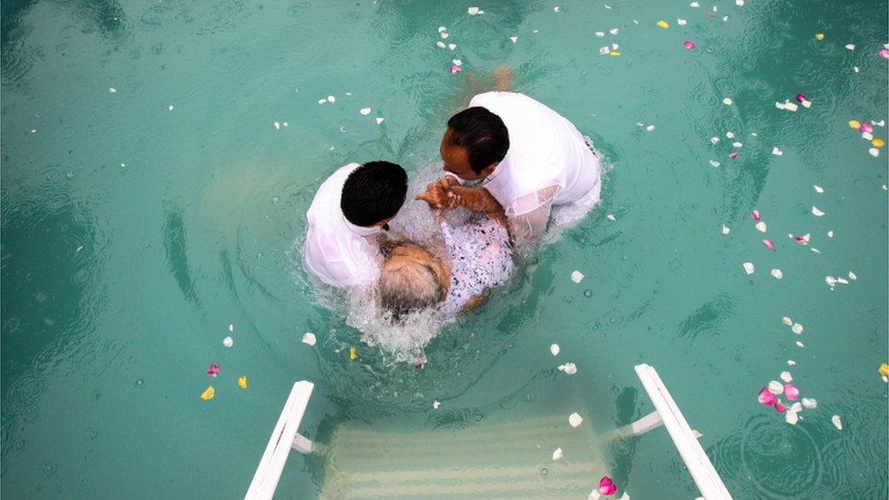 An elderly woman is baptised during the annual gathering of the La Luz del Mundo church in Guadalajara