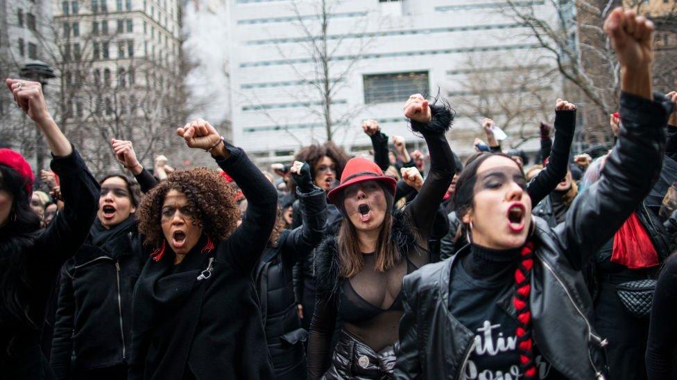 Women protesting with fists in the air in front of the court where Hollywood mogul Harvey Weinstein attends a pretrial session - 10 January 2020