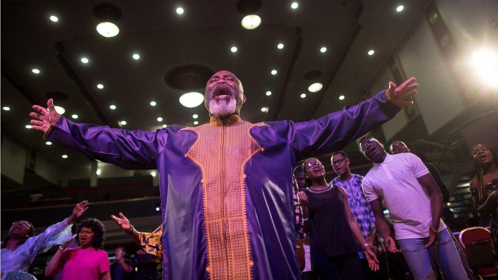 Worshippers pray during Sunday service at the House of Praise church in London