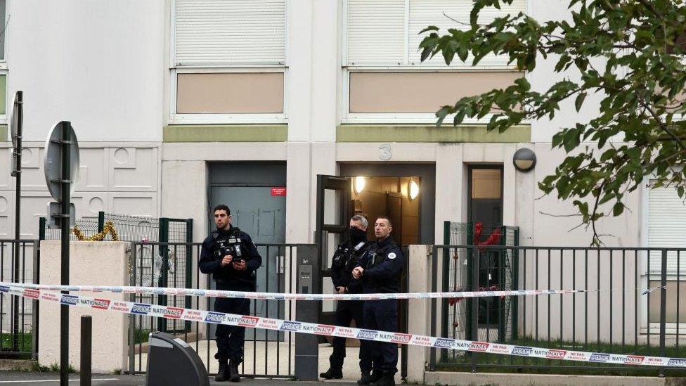 French police stand in front of a building where five bodies were found dead in Meaux, near Paris