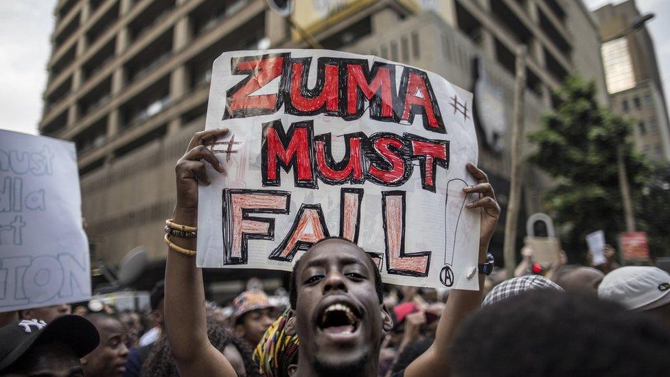 A student holds a placard reading "Zuma must fall" outside the Luthuli House, the ANC headquarters, in Johannesburg, South Africa - 22 October 215