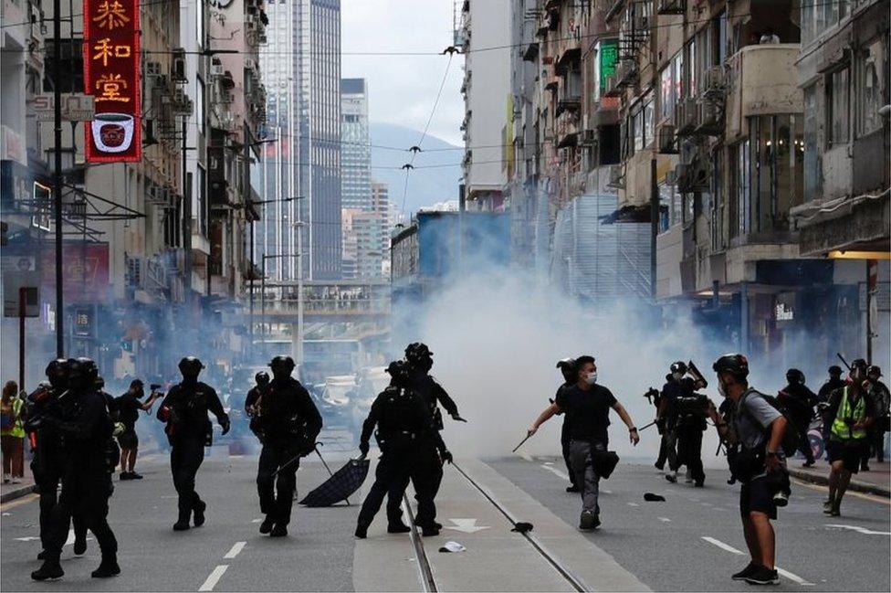 Riot police fire tear gas into the crowds to disperse anti-national security law protesters during a march at the anniversary of Hong Kong"s handover to China from Britain in Hong Kong, China July 1, 2020.