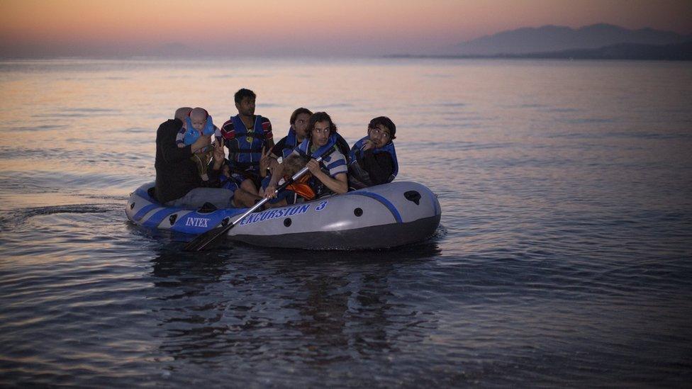 Migrant families from Syria arrive in an inflatable dinghy on the beach at sunrise on the island of Kos after crossing a three mile stretch of the Aegean Sea from Turkey 28 August 2015