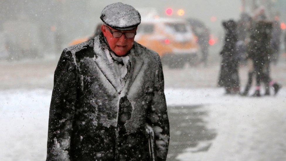 A man in Times Square with snow on him