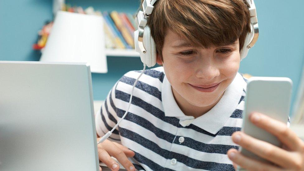 boy with smartphone and laptop