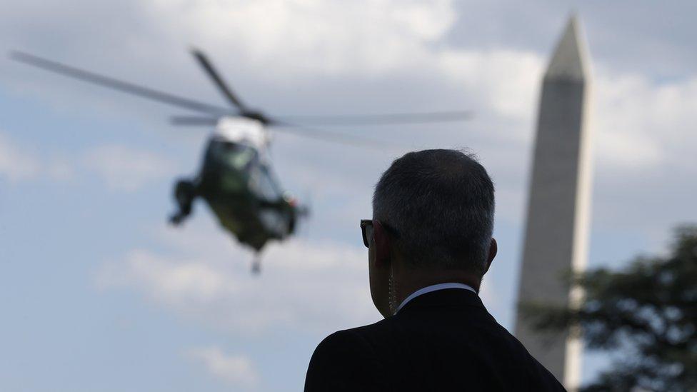 A U.S. Secret Service agent watches the Marine One helicopter arrive to collect President Donald Trump to spend the weekend at his New Jersey golf estate from the South Lawn of the White House in Washington, U.S., June 9, 201