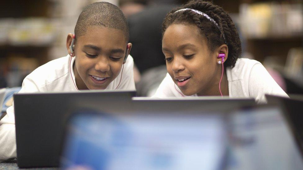 Stock shot of kids at school with computers