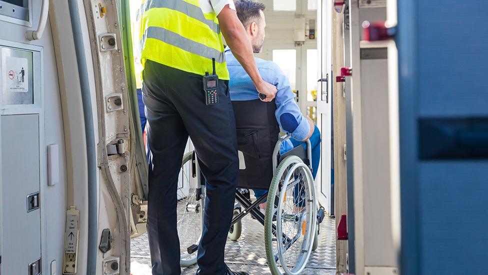 Man in wheelchair helped to board plane