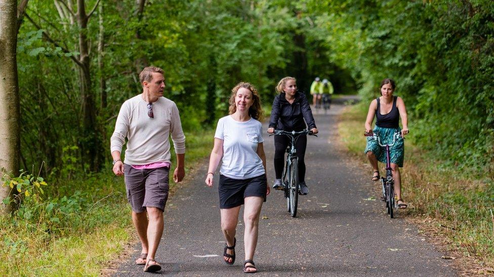 People walking along the railway path.