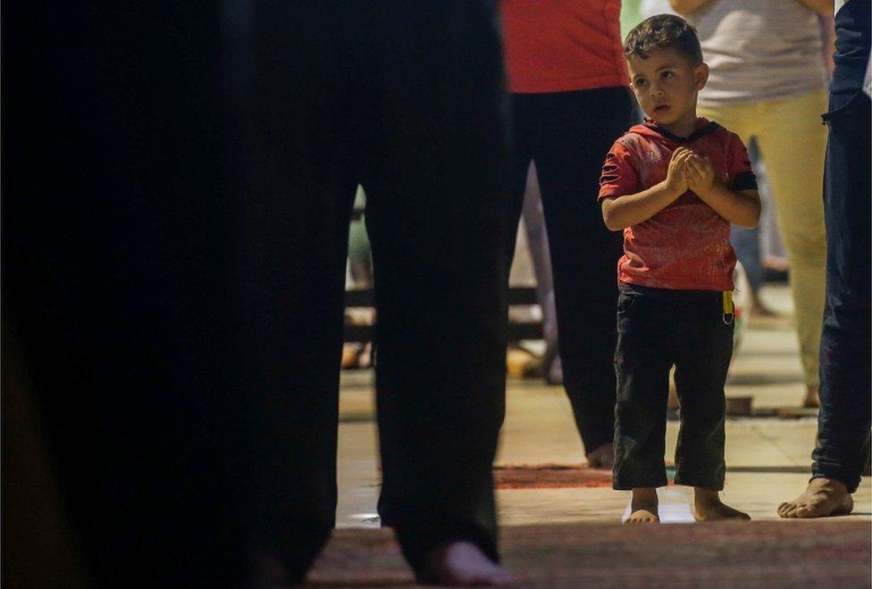 A young boy prays.