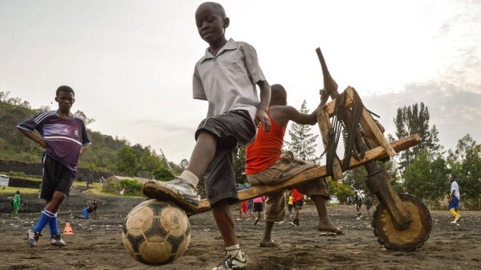 his photo taken on June 19, 2014 in Goma shows young boys playing football during a training session at the local TFC Cheval blanc (TFC White Horse) football school