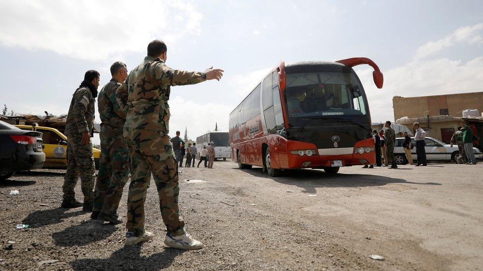 Buses carrying rebels and their families who have left Douma