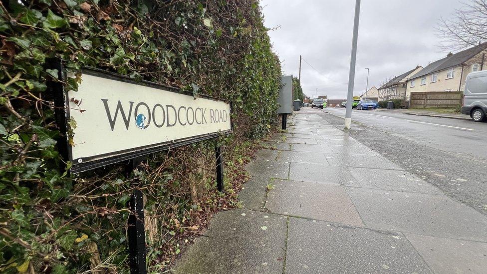 Woodcock Close road sign with the road in the background