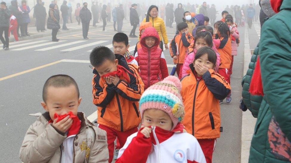 Pupils cover their noses after school in heavy smog on 23 December 2015 in Binzhou, China.