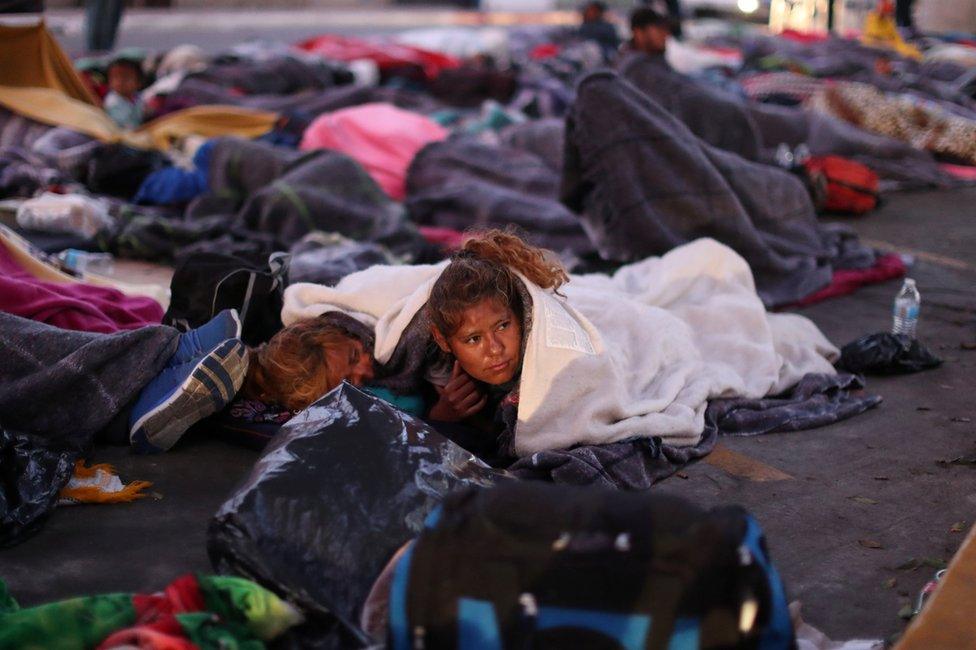 Members of a caravan from Central America trying to reach the United States sleep under a road bridge next to the US-Mexico border in Tijuana, Mexico, 23 November