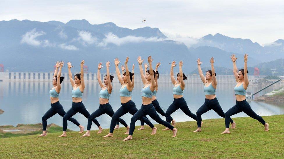 People practice yoga at a park in front of the Three Gorges Dam to welcome the International Day of Yoga, in Zigui County on June 20, 2021 in Yichang, Hubei Province of China.