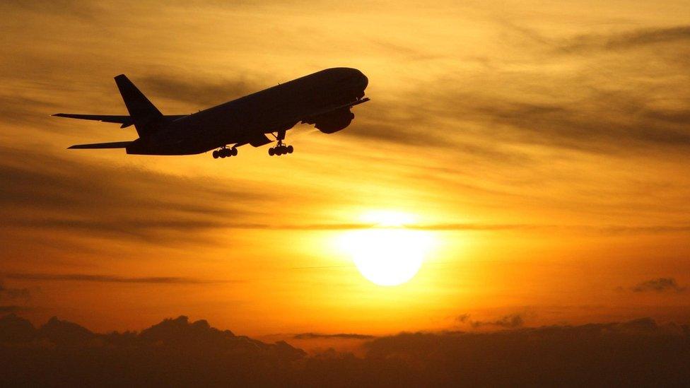 Plane takes off at sunset