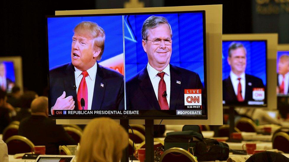 Republican U.S. presidential candidates businessman Donald Trump (L) and former Governor Jeb Bush (R) are seen debating on video monitors in the debate press room during the Republican presidential debate in Las Vegas, Nevada December 15, 2015