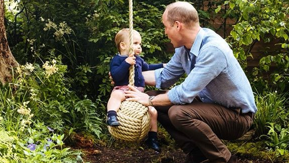 Prince William with Prince Louis on a rope swing.