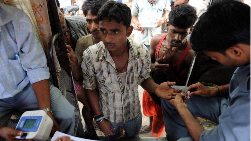 This picture taken on August 8, 2011, 19 year old Indian resident Vipin Yadav gets his blood sugar test done by Delhi government docters at a mobile clinic outside a slum in Geeta Colony area of New Delhi.