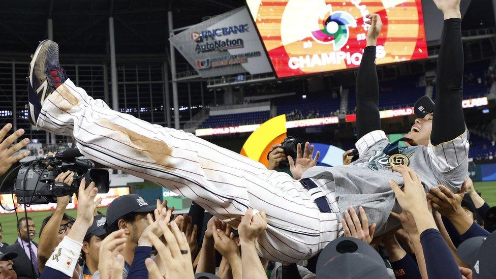 Shohei Ohtani is lifted up by his teammates in celebration after the game