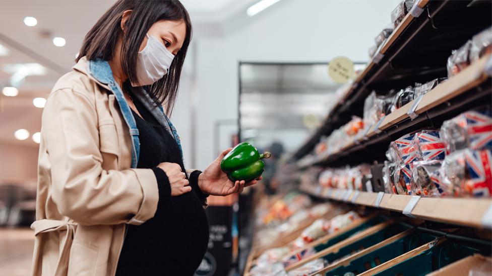 Woman shopping for food wearing face mask