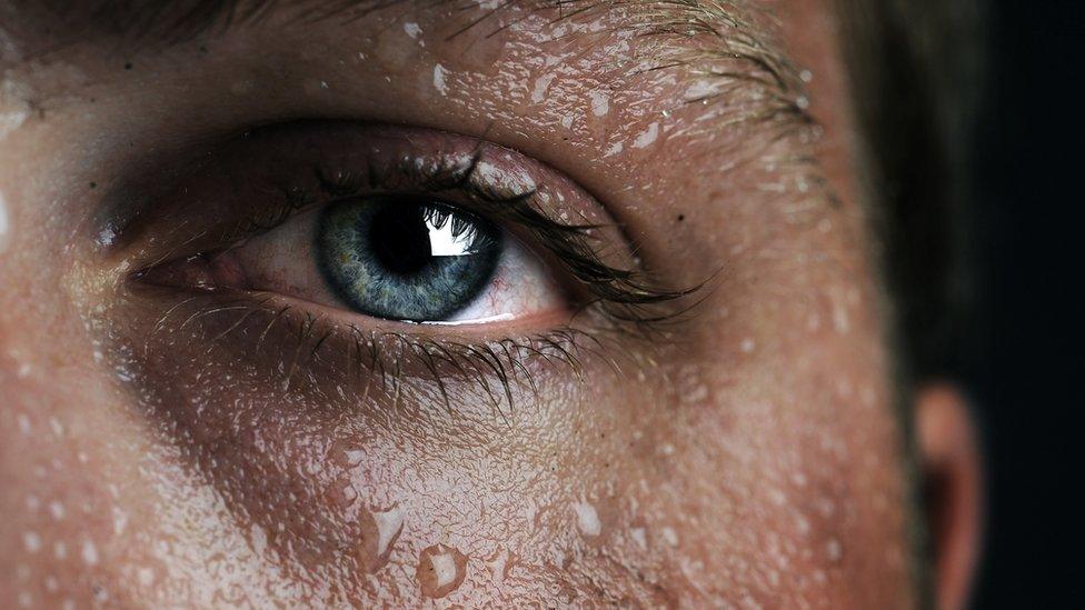 Close-up of woman's face covered in sweat