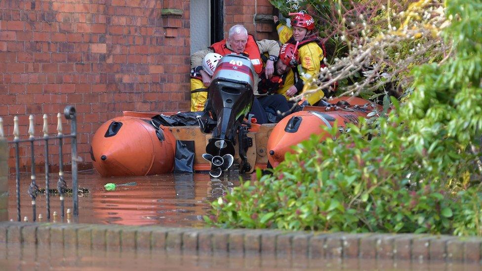 A man is helped from his home in Carlisle by rescue teams