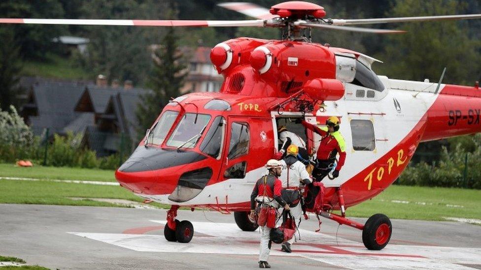 Mountain rescue team (TOPR) members board a helicopter in Poland August 18