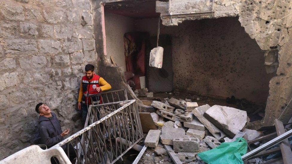 Palestinians inspect the damaged house where Israeli forces killed three Palestinians during a raid in the old city of Nablus, in the occupied West Bank (4 May 2023)