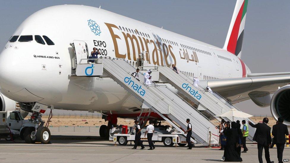 Visitors look at an Emirates airline"s Airbus A380 dislayed at the Dubai Airshow