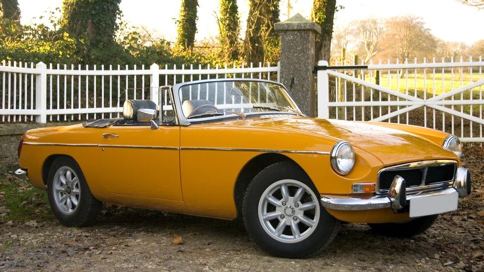 A yellow soft top car