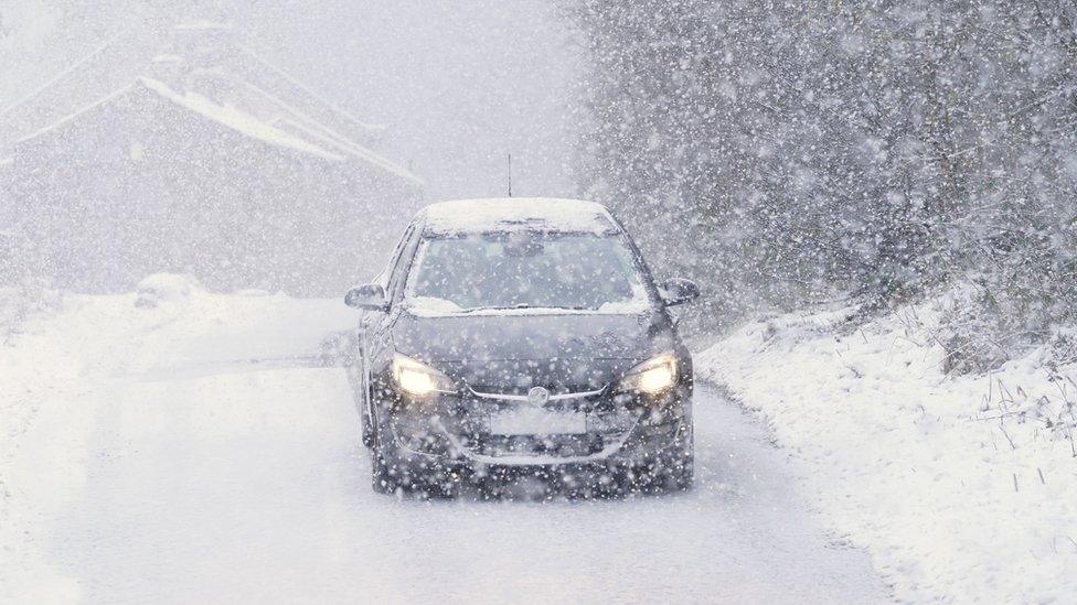 A car drives in heavy snow