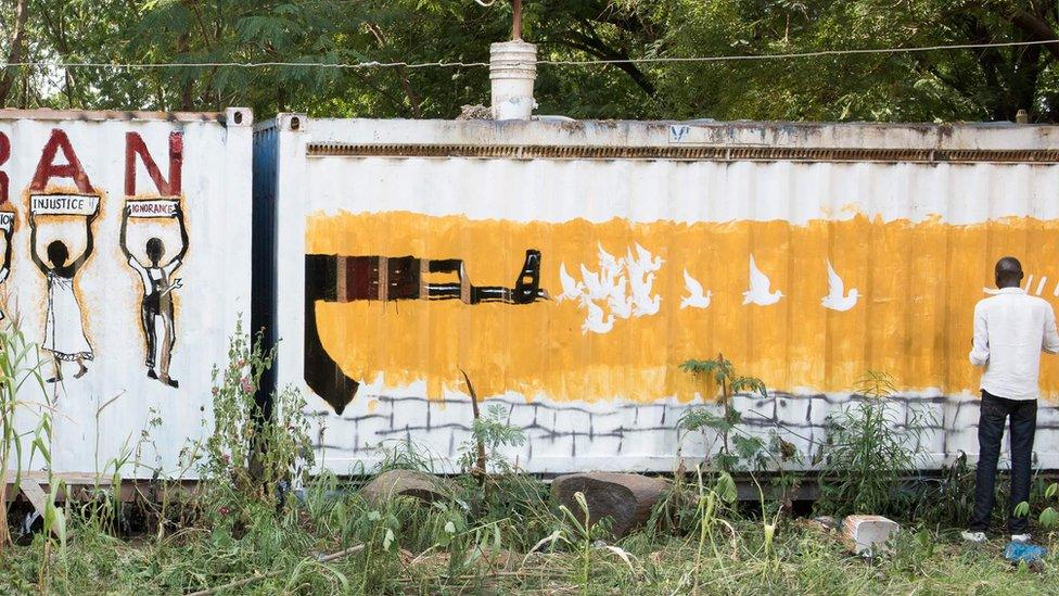 Painting of a gun firing out doves of peace on a shipping container