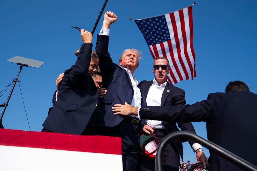 Donald Trump is surrounded by U.S. Secret Service agents at a campaign rally, Saturday, July 13, 2024, in Butler, Pa