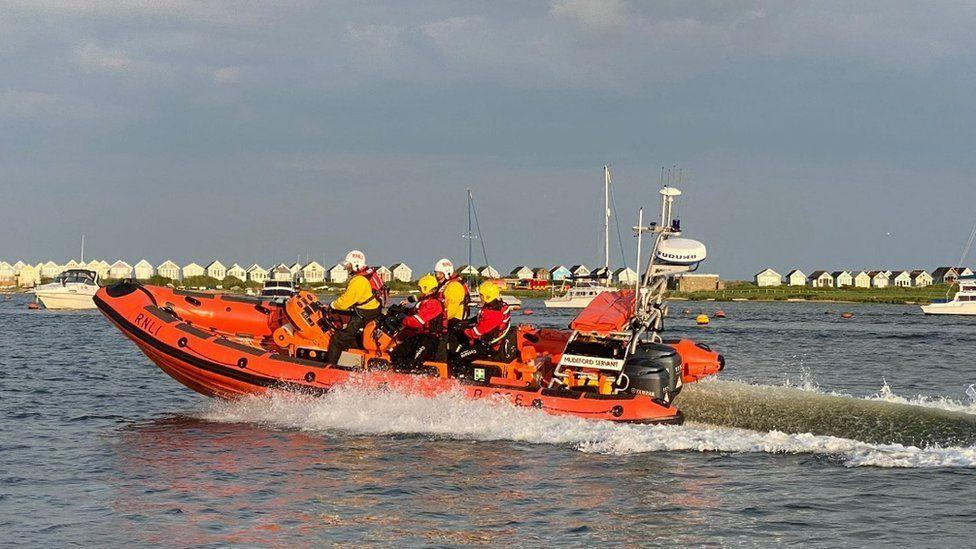 Mudeford Lifeboat with crew onboard travelling on the water