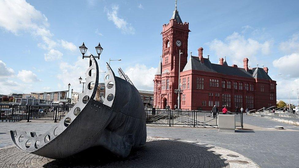 Cardiff Bay, showing ship-face sculpture, with Senedd and Pierhead building in the background