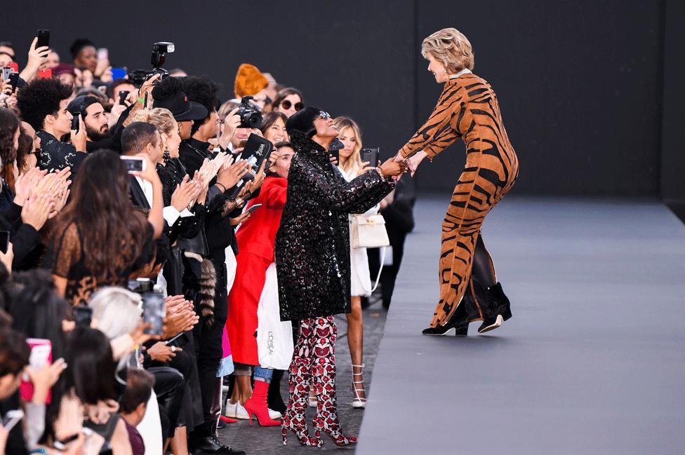 Naomi Campbell says hello to Jane Fonda on the catwalk