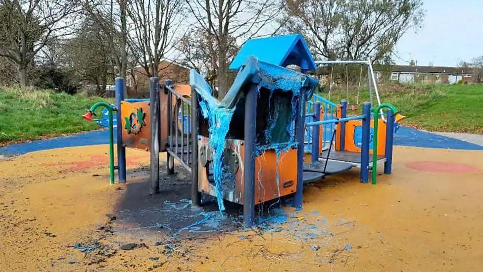 A picture showing the brightly coloured play equipment in Bellfield Park after the fire with the top part melted and scorch marks around the side