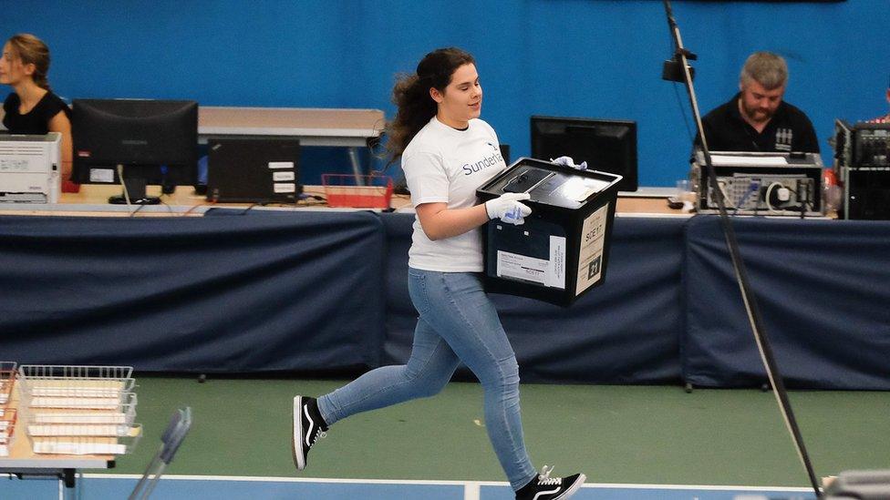 A woman running with a ballot box at the Sunderland count